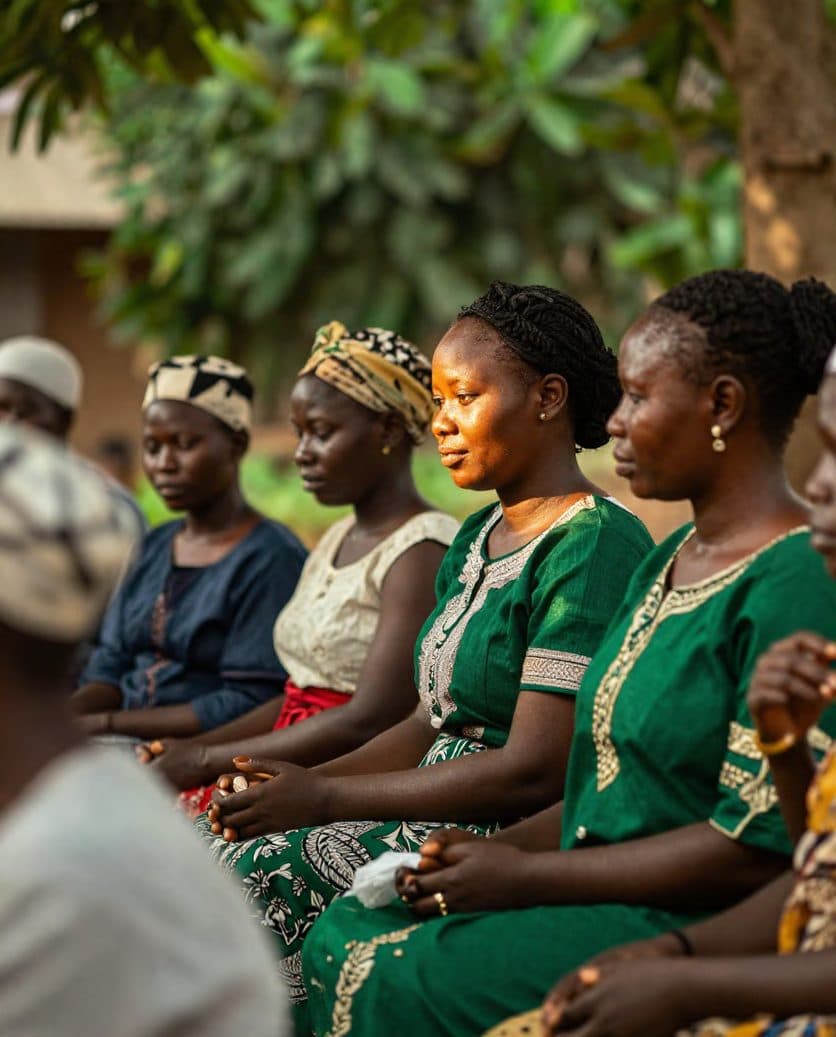Women seated together outdoors at a community health session